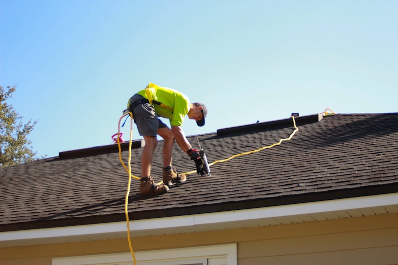 Roofer working on a roof with a drill